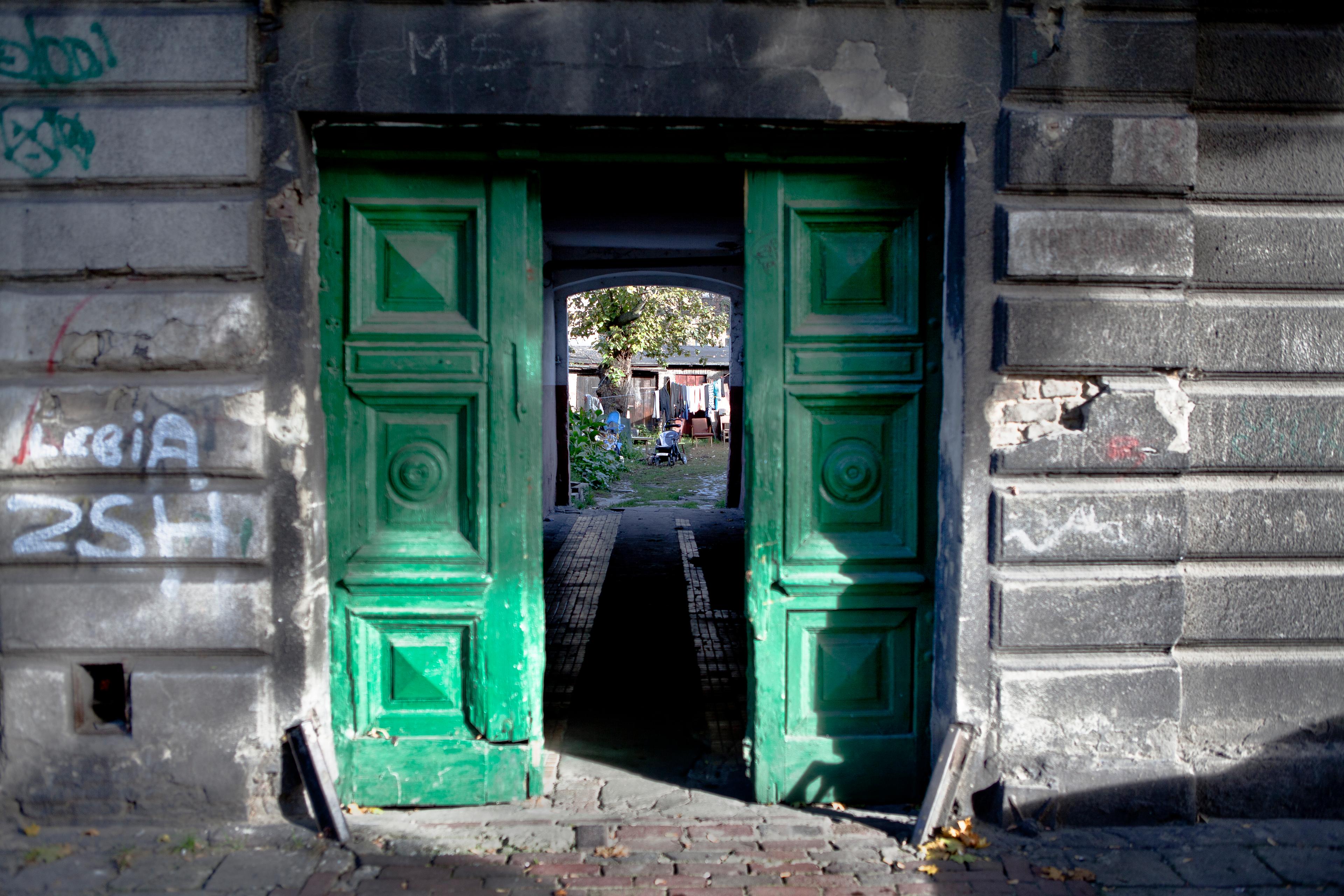 Wejście przez zielone drzwi do kamienicy