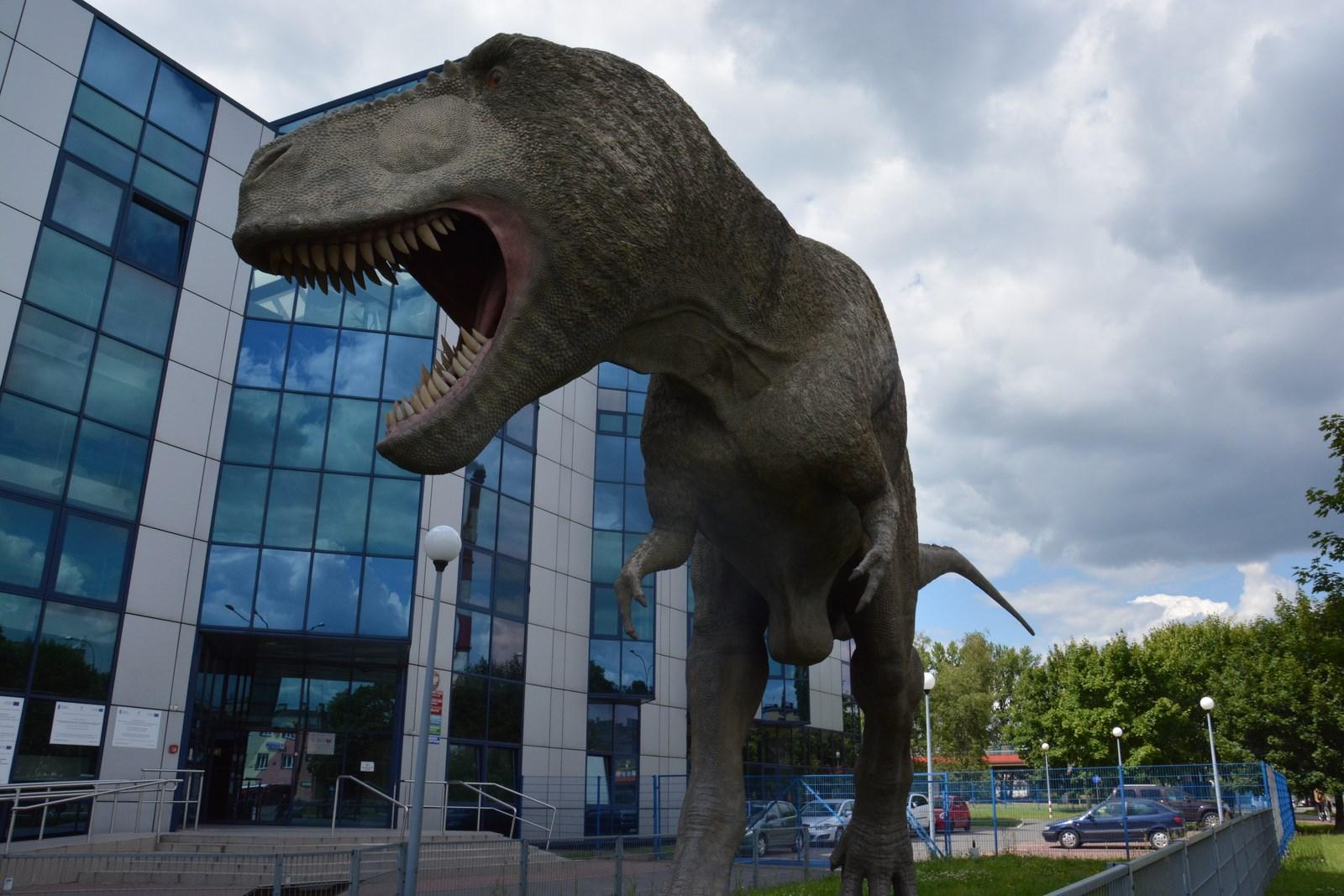 Dinozaur stojący przed szklanym budynkiem