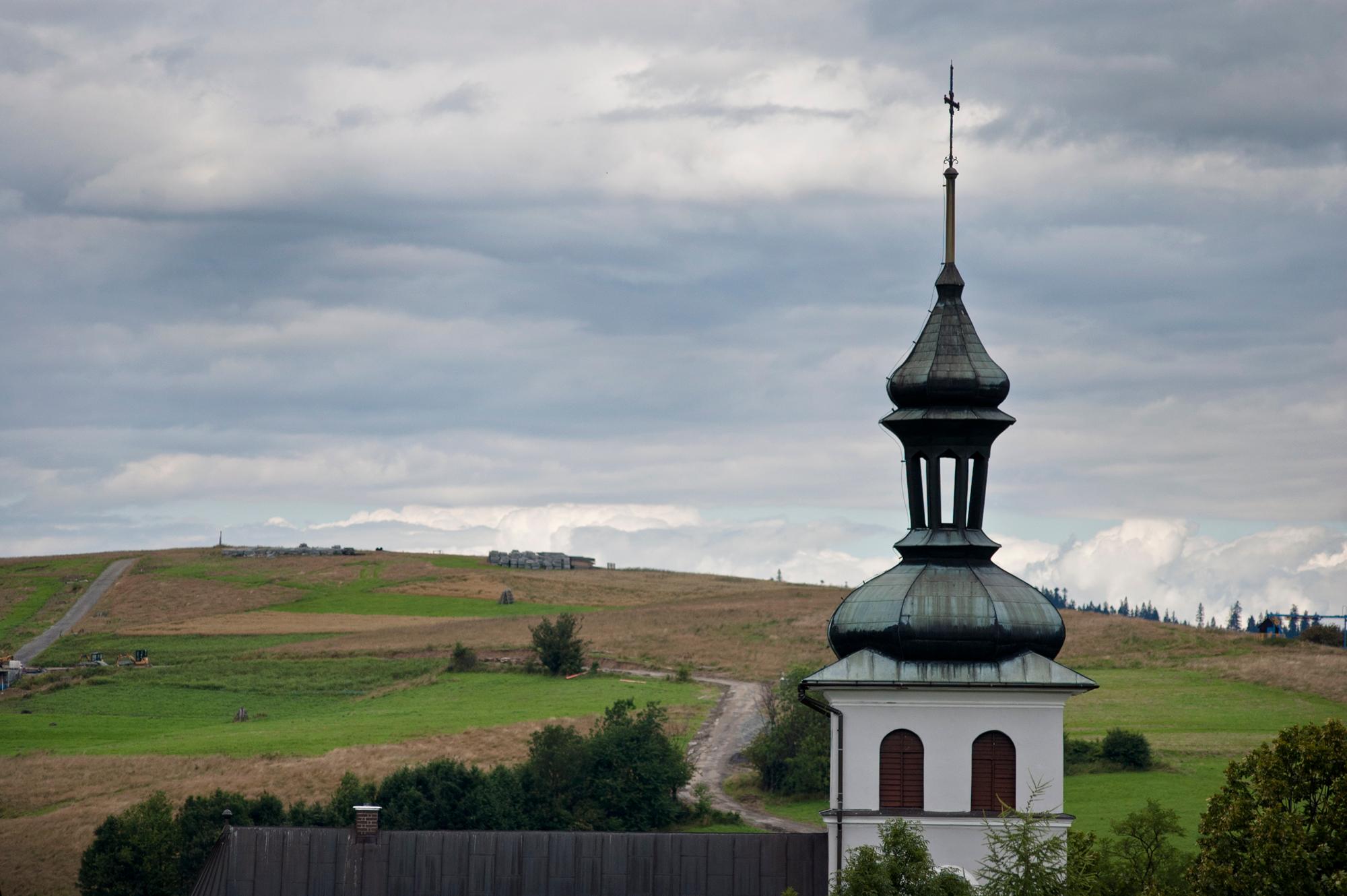Widok na wieżę kościoła i łąki
