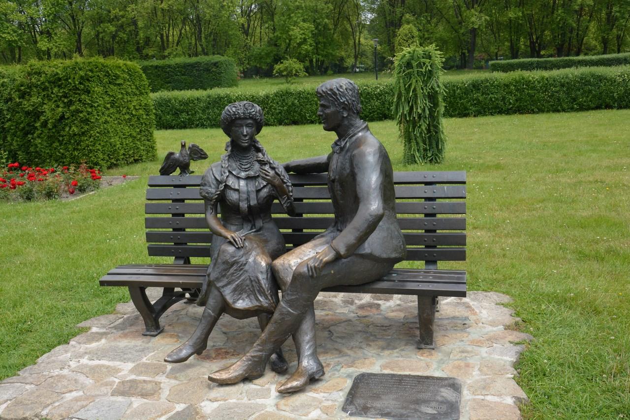 Ławka na której siedzi mężczyzna i kobieta odlani z brązu