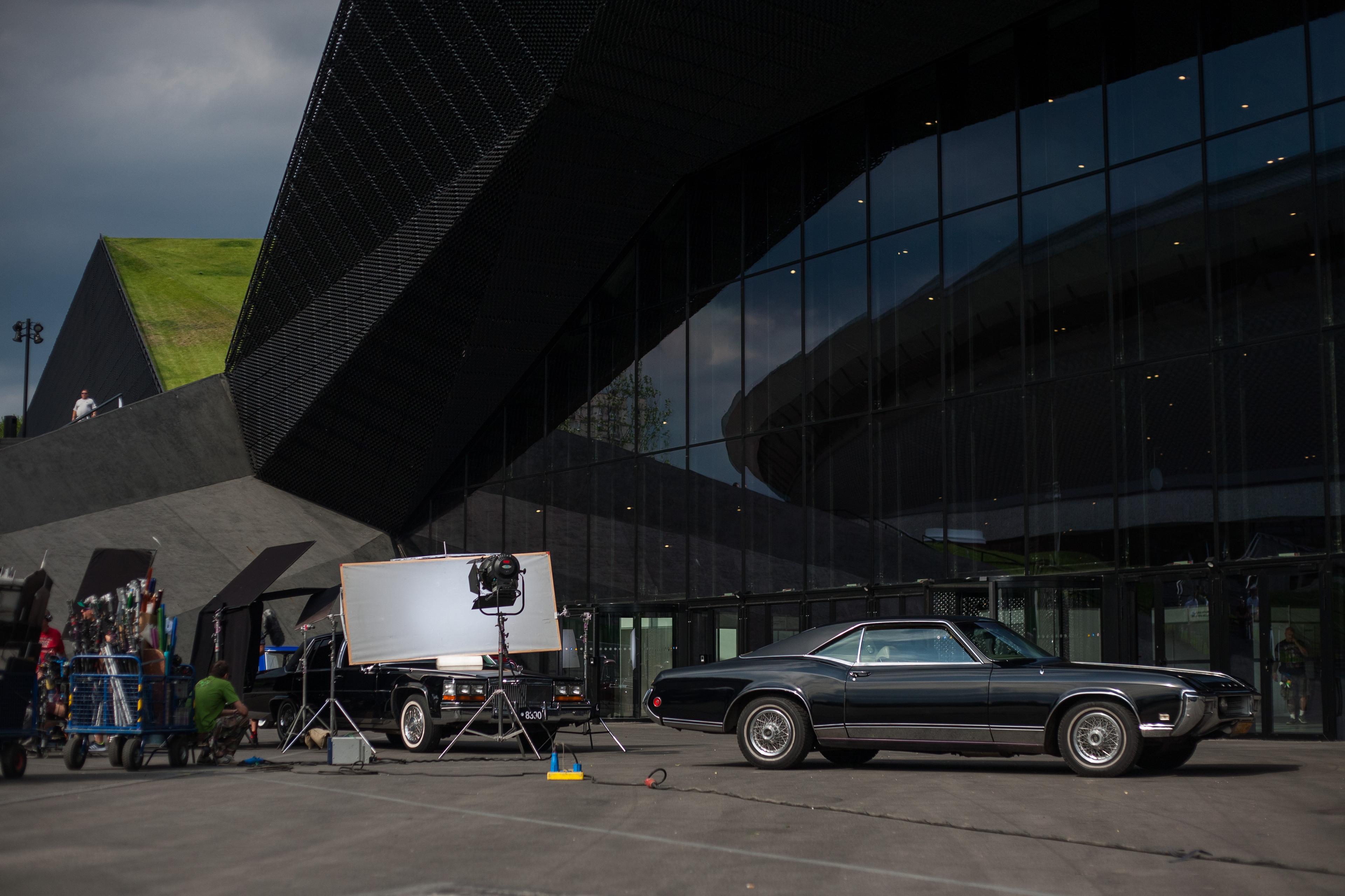 Plan ekipy filmowej w trakcie nagrywania sceny z dwoma samochodami