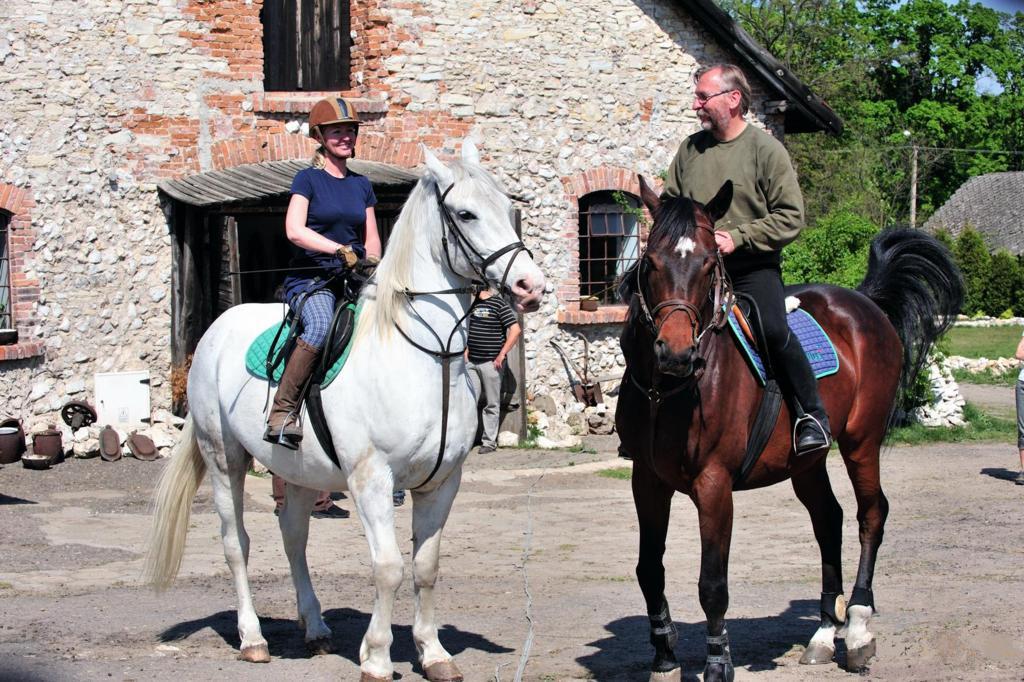 Dwa stojące konie na nich siedzą ludzie