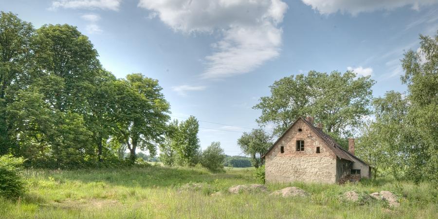 Budynek gospodarstwa otoczony zielenią