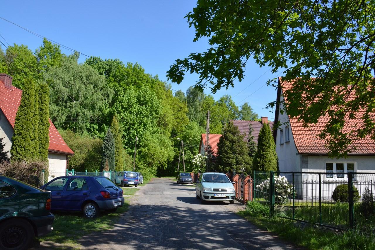 Ulica z domami przy której stoją auta