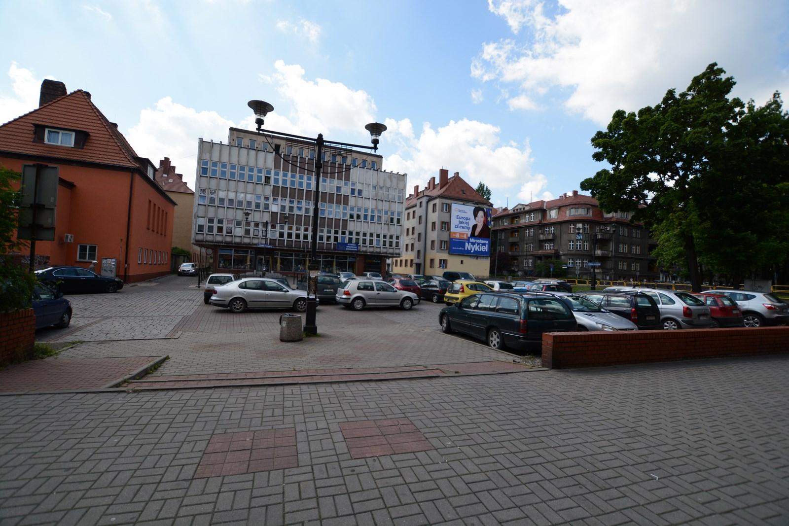 Parking z autami wśród zabudowań